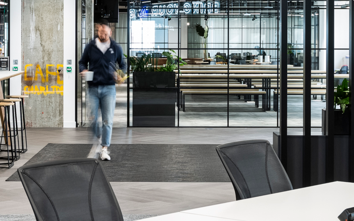 Person walking out of the office with a mug