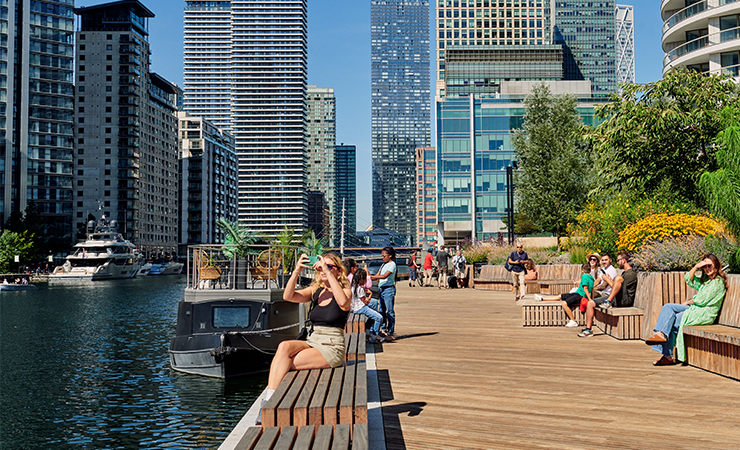 People sitting by the water in the sunshine