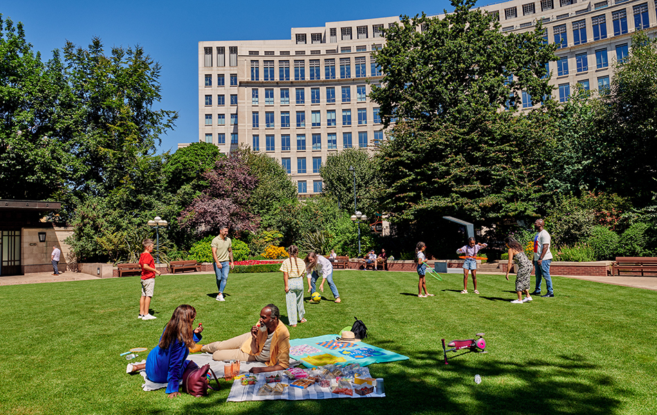 People sitting in Westferry Circus in the sunshine