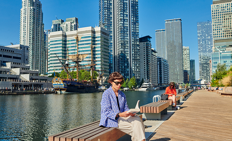 Woman sitting dockside in Wood Wharf